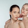 attractive naked multiethnic women posing for fashion shoot, isolated on grey, natural beauty